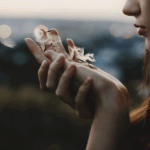 Woman blowing flower seeds on a Sacred Pause