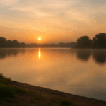 Serene beach scene with the sun low over the water